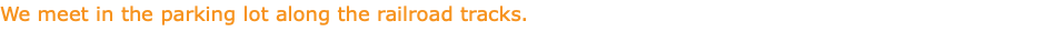 We meet in the parking lot along the railroad tracks.
